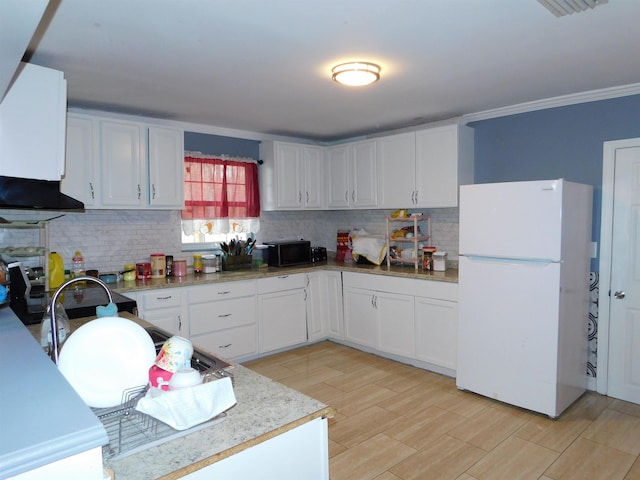 287 Tyre Rd, Havana, FL 32333 - kitchen featuring freestanding refrigerator, decorative backsplash, white cabinetry, light wood-style floors, and ornamental molding