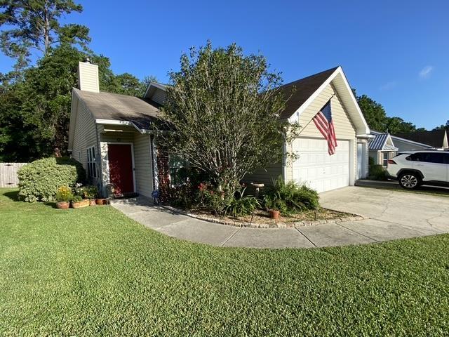 7124 Towner Trce, Tallahassee, FL 32312 - view of front facade featuring concrete driveway, a front yard, a chimney, and a garage