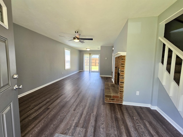 unfurnished living room with ceiling fan, dark hardwood / wood-style flooring, and a fireplace