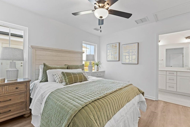 bedroom featuring ceiling fan, light hardwood / wood-style floors, and ensuite bath