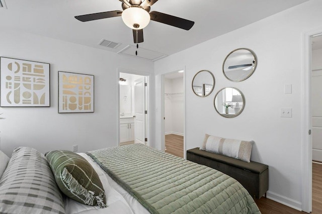 bedroom featuring a spacious closet, dark hardwood / wood-style floors, ceiling fan, and a closet