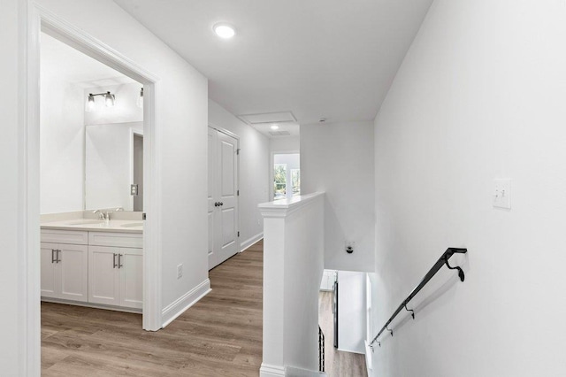 corridor with sink and light hardwood / wood-style flooring