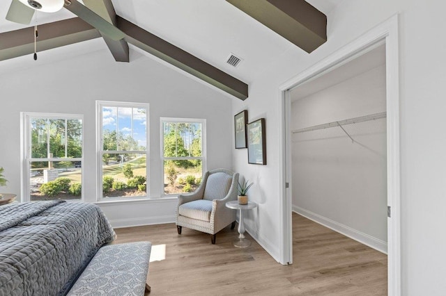 bedroom featuring light wood-type flooring, lofted ceiling with beams, ceiling fan, and a closet