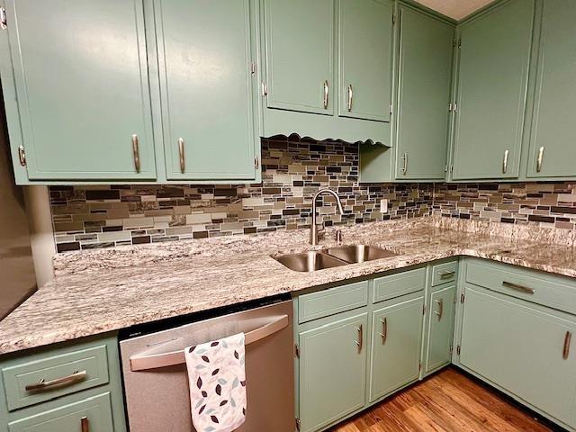 2401 Mexia Ave, Tallahassee, FL 32304 - kitchen with stainless steel dishwasher, a sink, light countertops, and decorative backsplash