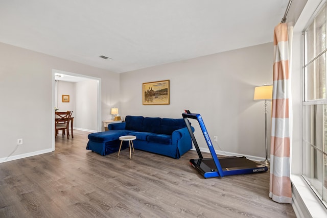 living room featuring visible vents, baseboards, and wood finished floors