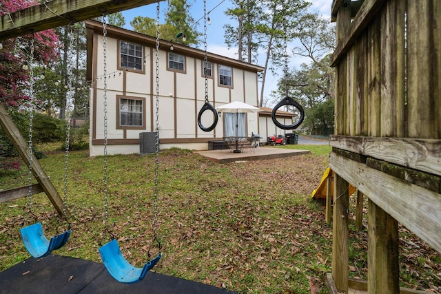 back of house with a patio, a yard, central AC, and stucco siding