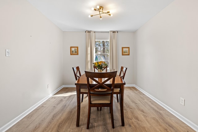 dining space featuring light wood-style floors and baseboards