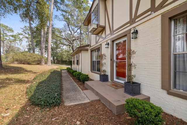 view of exterior entry featuring brick siding