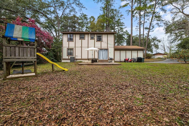 back of house with a lawn, a playground, and central air condition unit