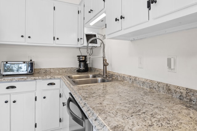 kitchen featuring white cabinets, a sink, and light countertops