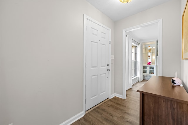 foyer featuring wood finished floors and baseboards