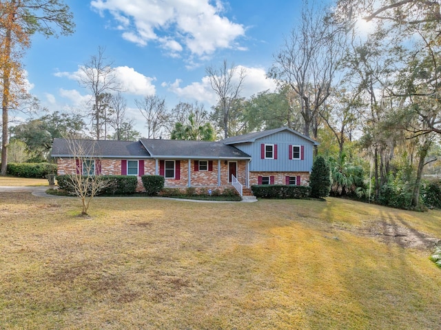 tri-level home with a porch and a front yard