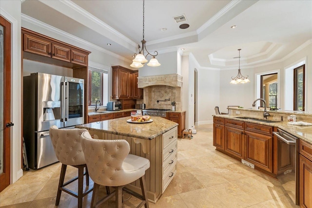 8017 Oak Grove Plantation Rd, Tallahassee, FL 32312 - kitchen with a tray ceiling, stainless steel appliances, a sink, light stone counters, and crown molding