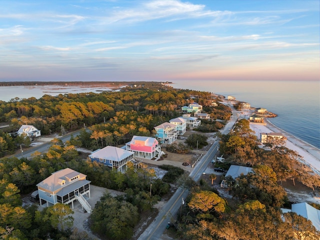 aerial view at dusk featuring a water view