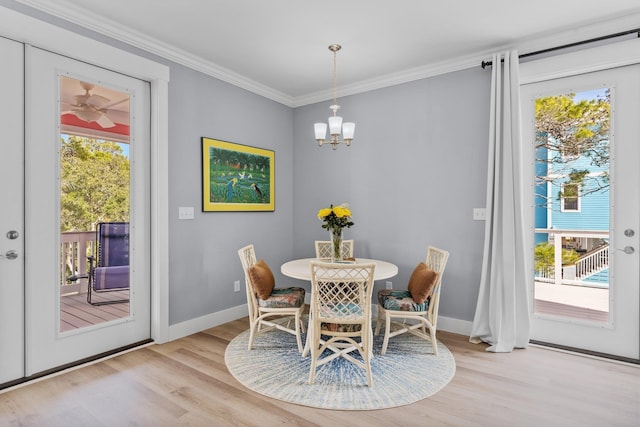 dining room with an inviting chandelier, crown molding, a wealth of natural light, and light wood-type flooring