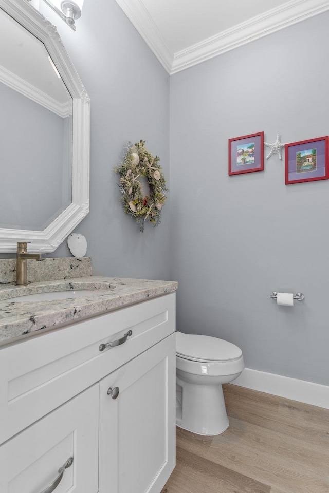 bathroom with vanity, hardwood / wood-style floors, crown molding, and toilet