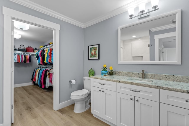 bathroom featuring toilet, a shower, crown molding, vanity, and hardwood / wood-style floors