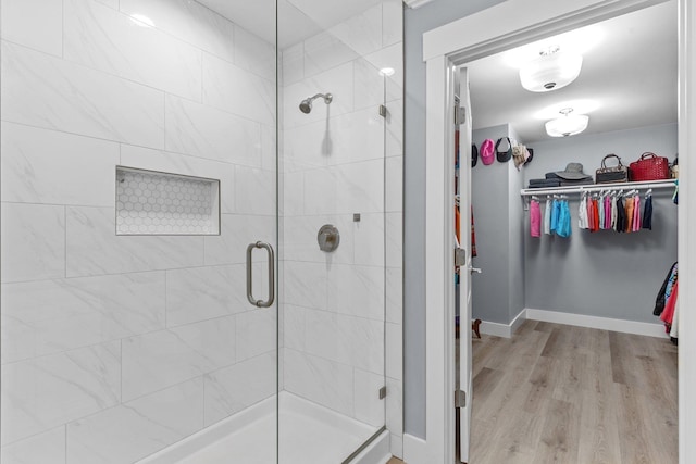 bathroom featuring wood-type flooring and a shower with shower door