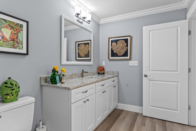 bathroom with vanity, wood-type flooring, ornamental molding, and toilet