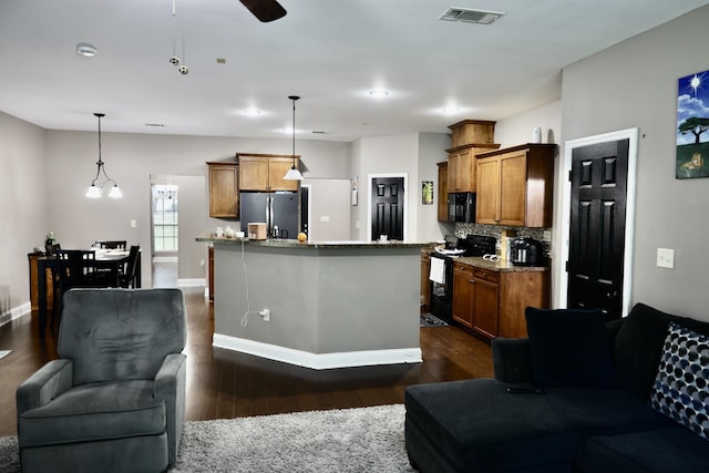 325 Mine Rd, Midway, FL 32343 - kitchen featuring black appliances, brown cabinetry, dark wood-type flooring, tasteful backsplash, and open floor plan