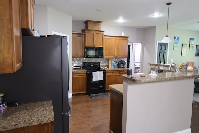 325 Mine Rd, Midway, FL 32343 - kitchen with black appliances, brown cabinets, dark wood-style floors, decorative backsplash, and pendant lighting