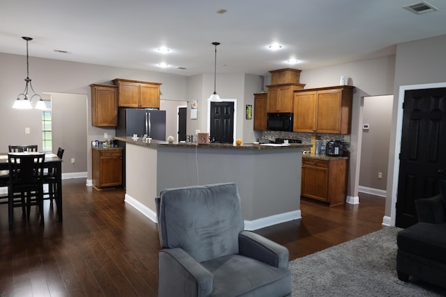 325 Mine Rd, Midway, FL 32343 - kitchen featuring black microwave, brown cabinets, dark wood-style flooring, freestanding refrigerator, and recessed lighting