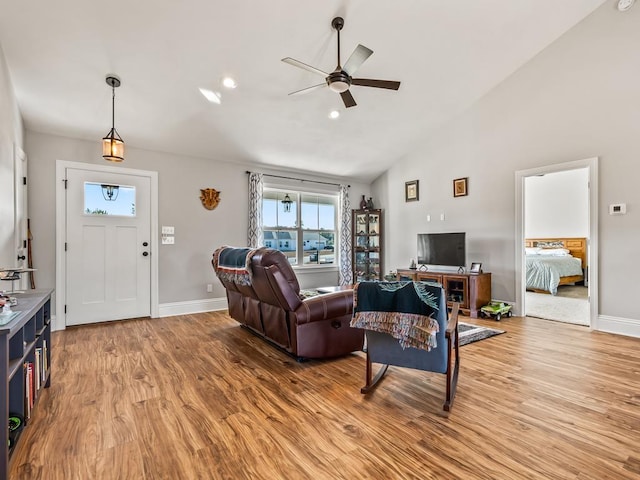 living room featuring ceiling fan, high vaulted ceiling, and light wood-type flooring