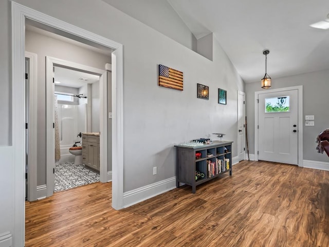 entrance foyer with hardwood / wood-style floors and vaulted ceiling