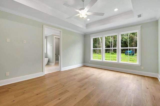 unfurnished room featuring crown molding, ceiling fan, a tray ceiling, and light wood-type flooring