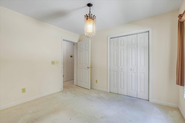 4545 Thomasville Rd, Tallahassee, FL 32309 - unfurnished bedroom with a chandelier, carpet floors, a closet, and baseboards