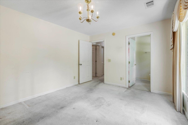 4545 Thomasville Rd, Tallahassee, FL 32309 - unfurnished bedroom featuring light colored carpet, a chandelier, baseboards, and a walk in closet