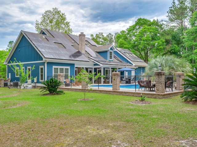 back of house with a yard, a fenced in pool, and a patio