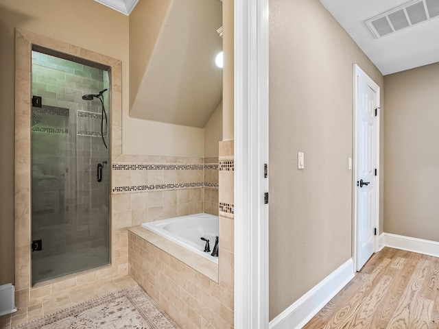 bathroom with shower with separate bathtub and hardwood / wood-style flooring