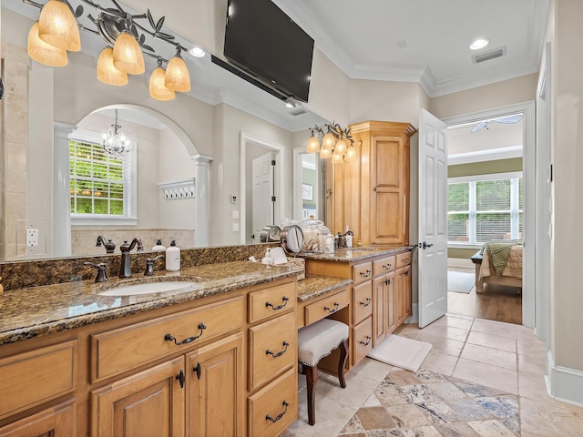 bathroom featuring tile patterned flooring, a healthy amount of sunlight, ornate columns, and ornamental molding