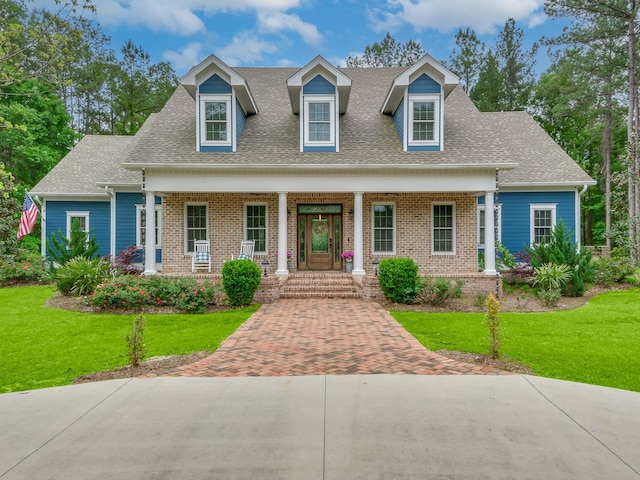 cape cod home featuring covered porch and a front yard