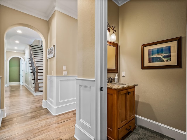 bathroom featuring vanity, hardwood / wood-style floors, and ornamental molding