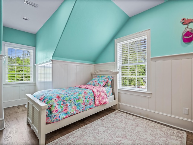 bedroom with vaulted ceiling, multiple windows, and dark hardwood / wood-style flooring