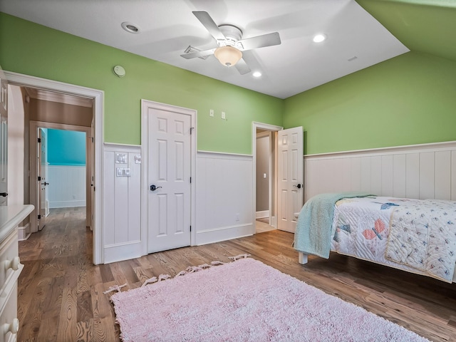 bedroom featuring hardwood / wood-style flooring, lofted ceiling, and ceiling fan