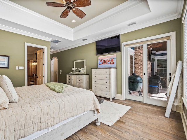 bedroom featuring crown molding, light wood-type flooring, access to exterior, a tray ceiling, and ceiling fan