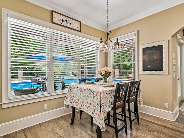 dining area featuring an inviting chandelier, hardwood / wood-style floors, and ornamental molding