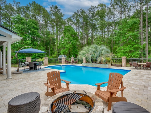 view of pool featuring a storage unit, an outdoor fire pit, and a patio area