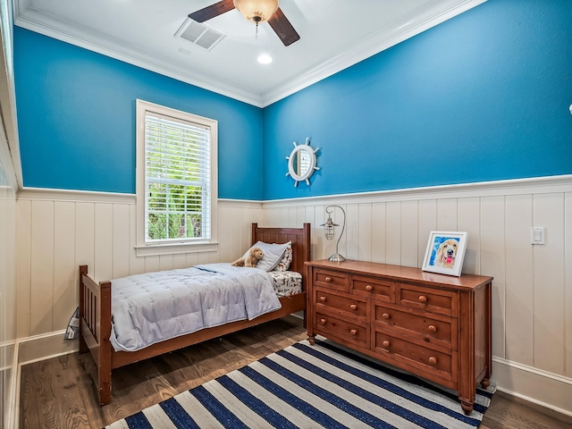 bedroom with dark hardwood / wood-style flooring, ceiling fan, and crown molding