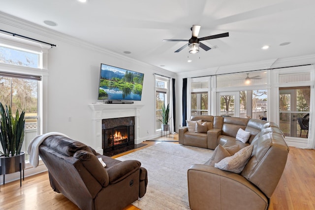 living room featuring a healthy amount of sunlight, light hardwood / wood-style flooring, and ornamental molding