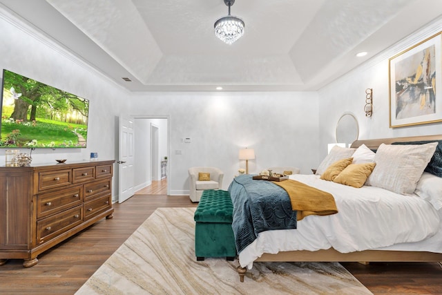 bedroom featuring hardwood / wood-style floors and a raised ceiling