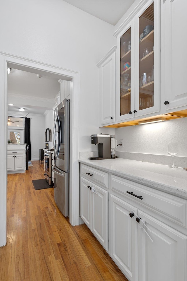 interior space with appliances with stainless steel finishes, light wood-type flooring, and white cabinets