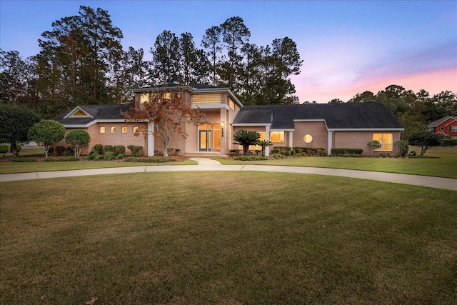 view of front of house with driveway and a lawn