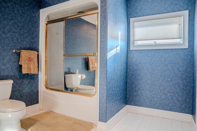 bathroom with shower / bath combination with glass door, tile patterned floors, and toilet