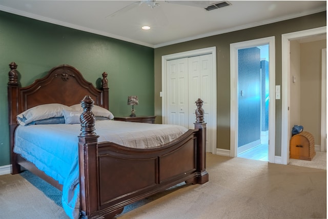 bedroom featuring a closet, ornamental molding, light colored carpet, ceiling fan, and ensuite bathroom