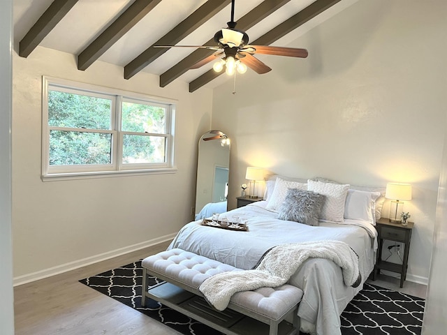 bedroom with hardwood / wood-style flooring, ceiling fan, and vaulted ceiling with beams