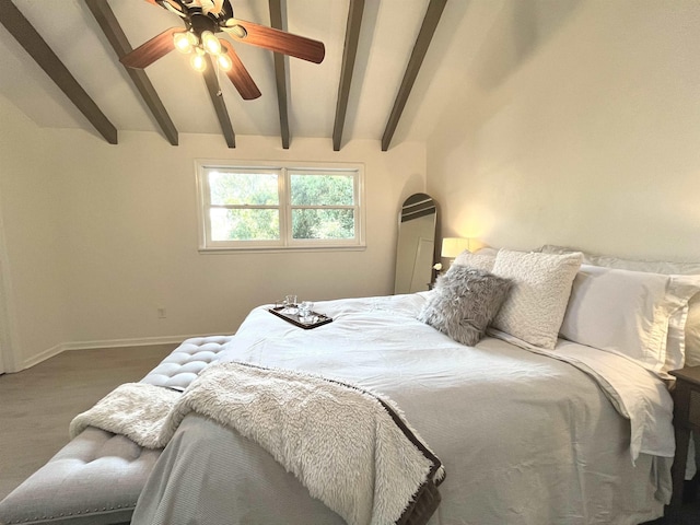 bedroom featuring ceiling fan and vaulted ceiling with beams